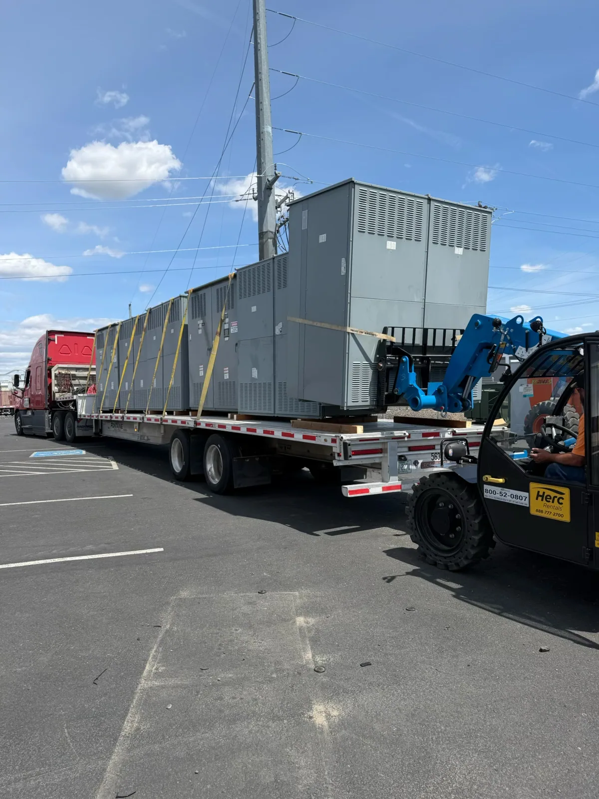 Switchgear sections loaded on a flatbed with a telehandler — Appleton, WI